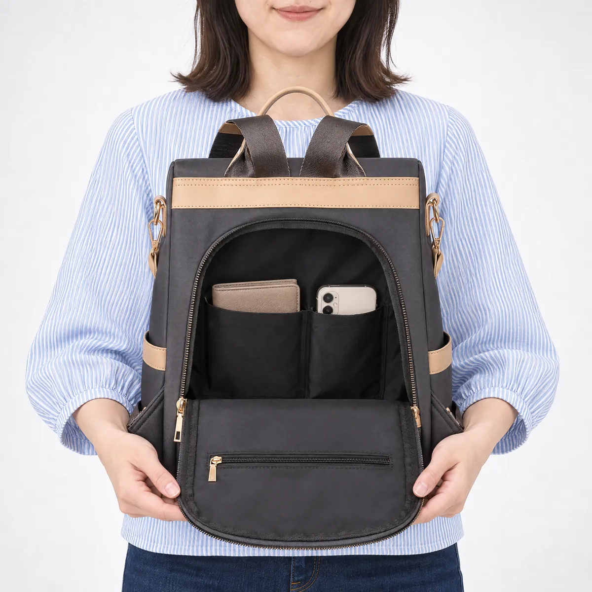 背面ファスナーを開けたグレーの防犯リュック。財布とスマートフォンが収まる内部の仕切りポケット