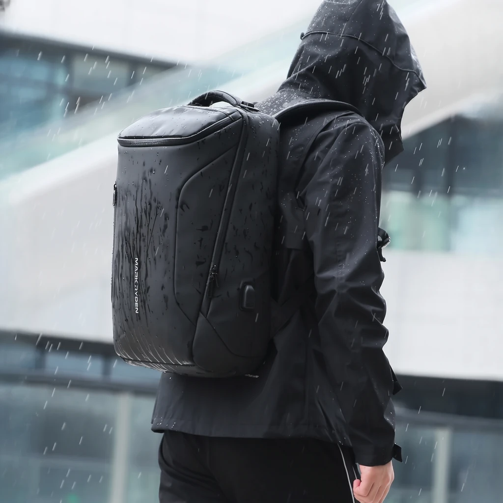 小雨の日のビジネスリュック 小雨の中でフードをかぶった男性が背負うビジネスリュック