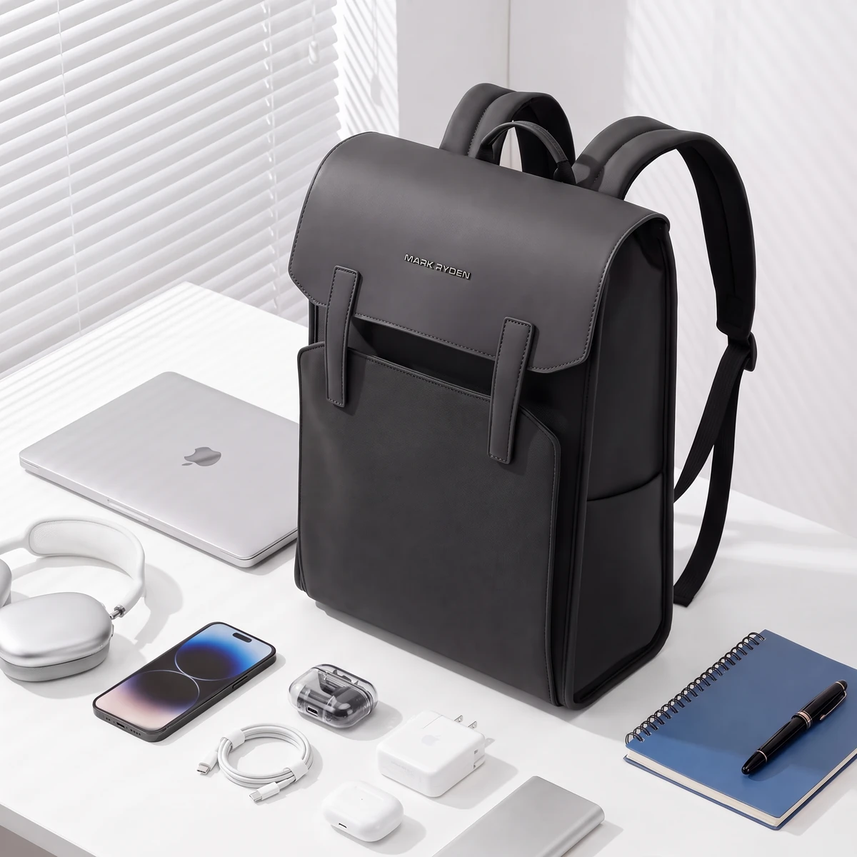 ノートPC、ヘッドホン、スマホ、ノートと並べたリュックでサイズ感がわかる