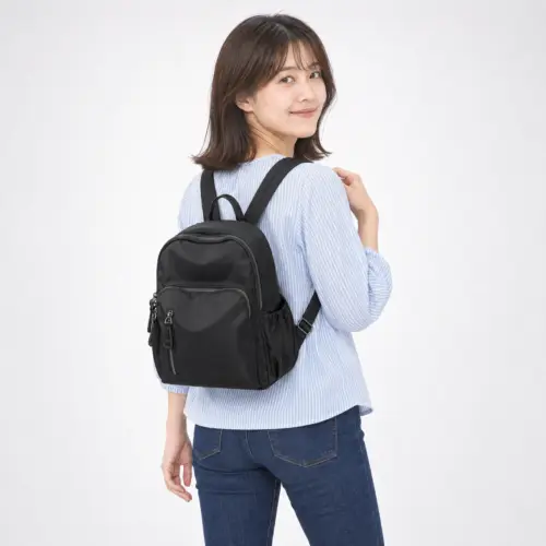 ブラック 背負った後ろ姿 ブラックのミニリュックを背負った後ろ姿。前ポケットと両サイドのポケット