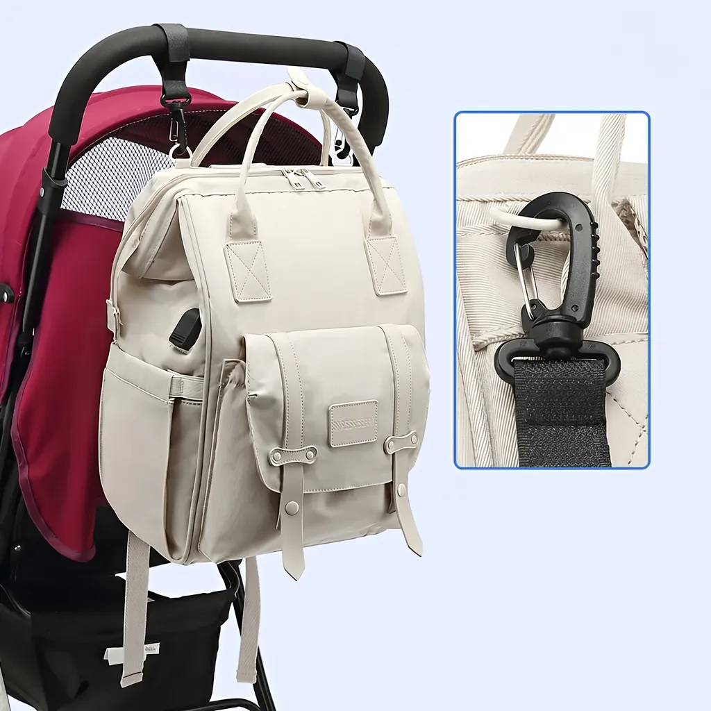 赤いベビーカーに掛けられた20L防水マザーズバッグ。カラビナフック部分のズームカット付きで、使いやすさを紹介する製品画像。