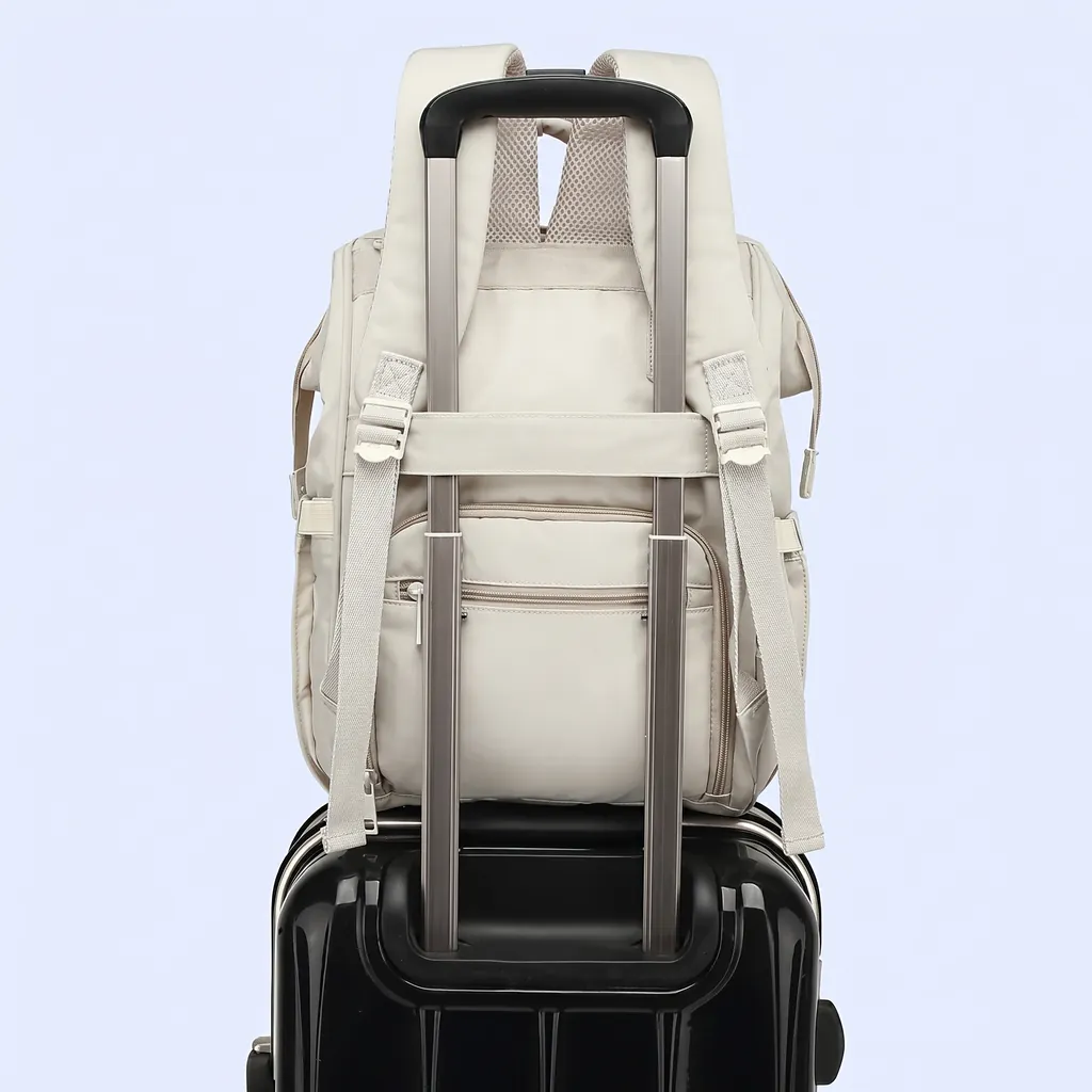 スーツケースのハンドルに固定された、きれいめ撥水マザーズリュック（20L）。旅行に便利なキャリーオン機能を紹介するスタイリッシュな一枚。