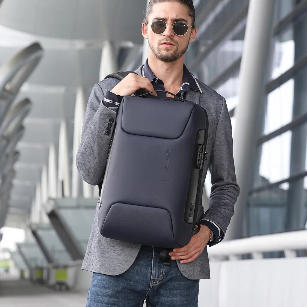 メンズ 生活防水 3WAY ビジネスリュック 20L グレーのブレザーを着てサングラスをかけた男性が、未来的な駅で生活防水3WAY20Lビジネスリュックを持つ姿