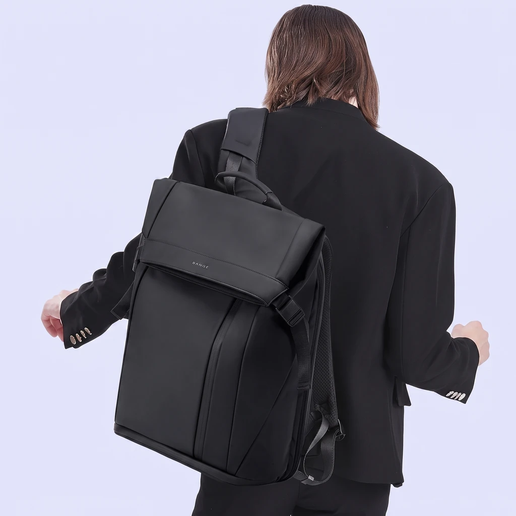 黒のスーツジャケットを着た男性の後ろ姿。15.6インチPC対応のシックなメンズビジネスリュック20Lを片方の肩に背負っています。