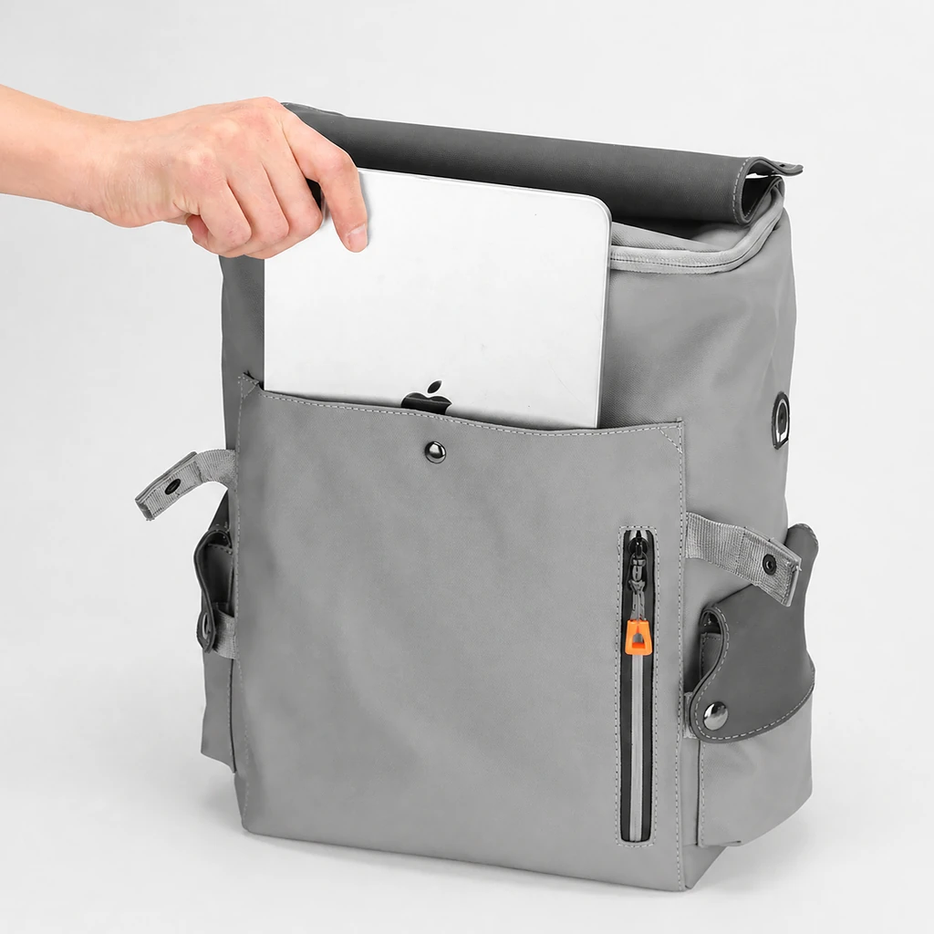 スタイリッシュな20LメンズPUレザービジネスリュック ノートパソコン収納 メンズ向けのスタイリッシュな20L PUレザービジネスリュック。フロントポケットにシルバーの薄型ノートパソコンをスマートに出し入れする様子。