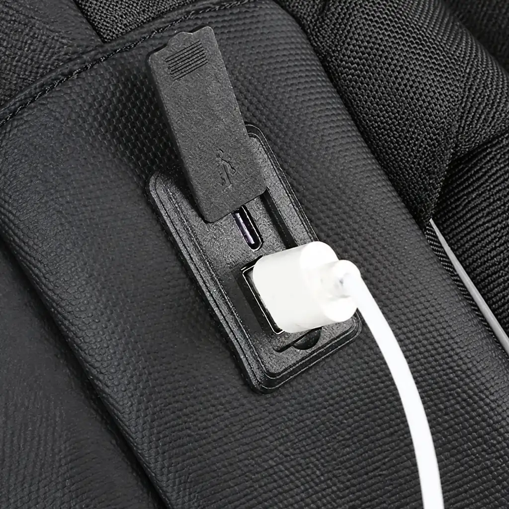 15.6インチ 生活防水スリムPCリュック USBポート 黒の生活防水素材を使用したスリムな15.6インチPCリュック。外部のUSBポートに白い充電ケーブルを接続した端子部分のアップ。
