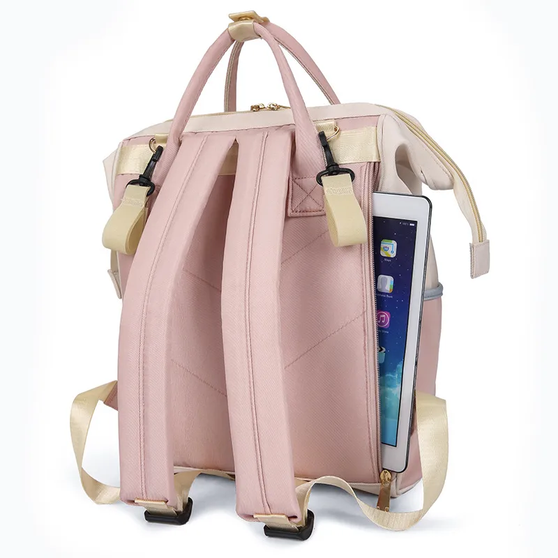 背面のファスナーポケットからタブレットが見えるピンクとベージュのマザーズリュック