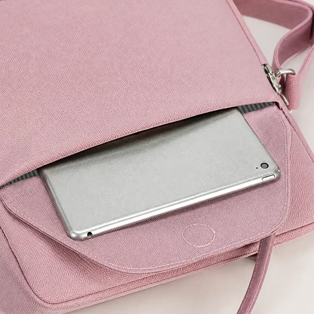 くすみピンクの可愛い撥水リュック。フロントポケットにタブレットを収納する様子と、ボーダー柄の裏地がのぞくおしゃれなディテール。