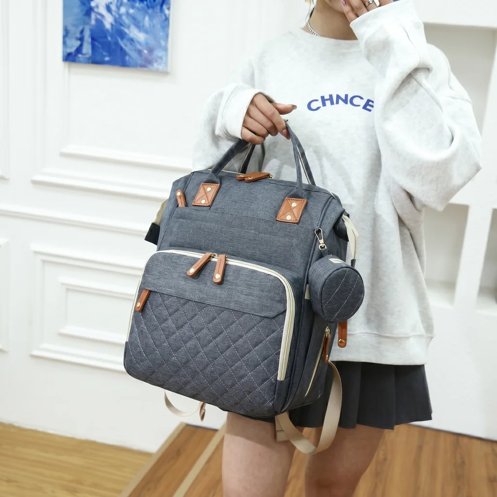Woman in a white sweatshirt holding a quilted mother's backpack cooler