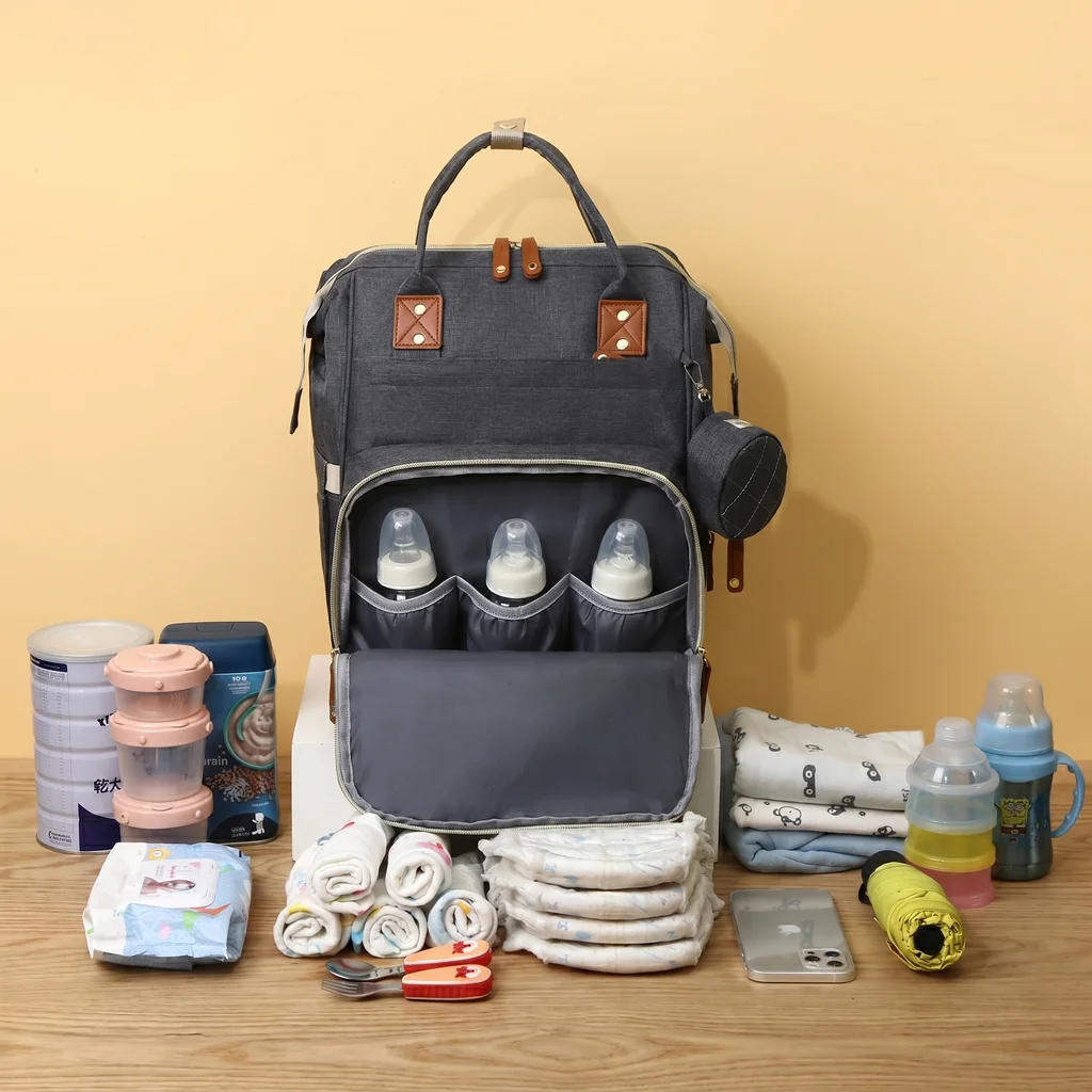 Quilted mother's backpack on a wooden table with diapers and baby formula