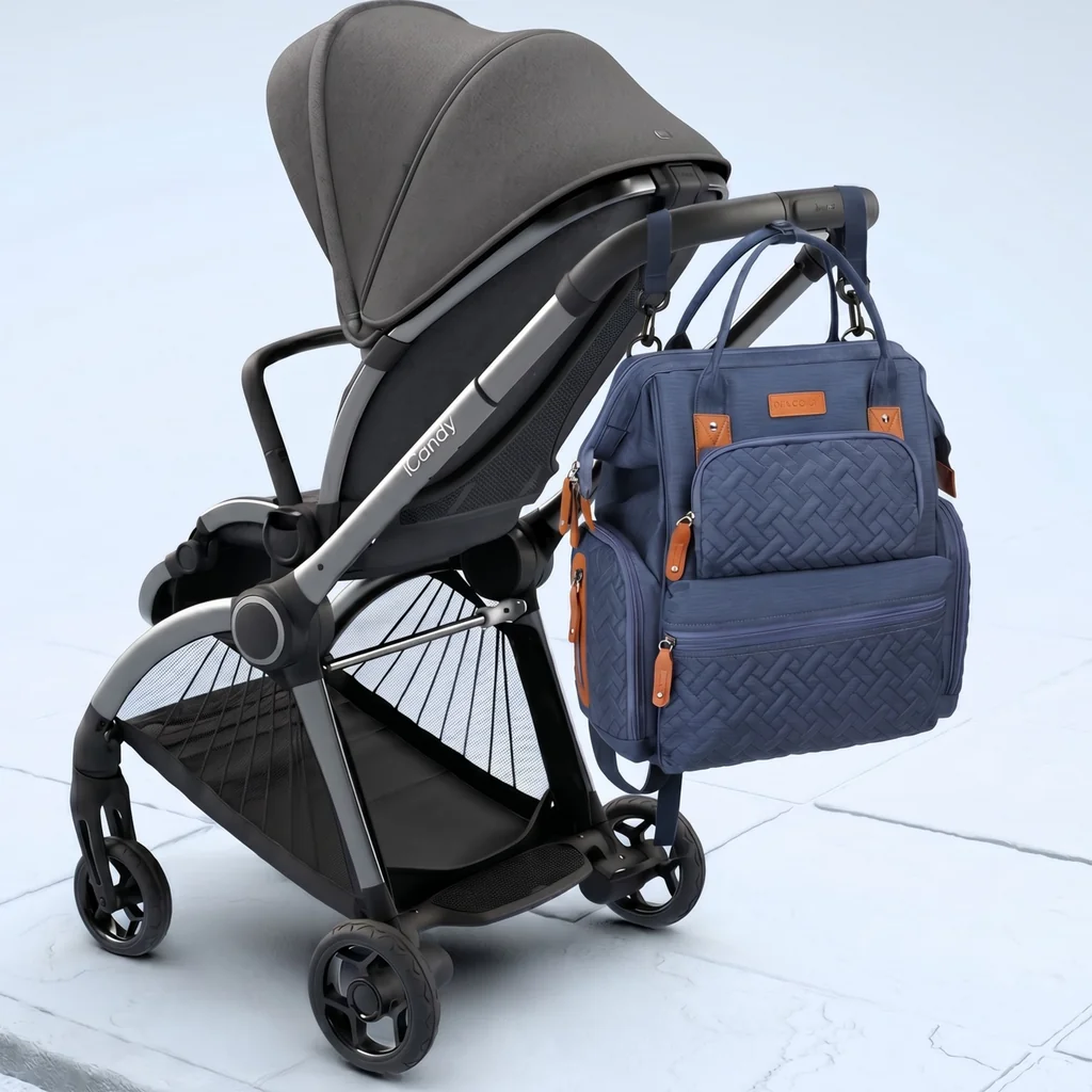 Waterproof quilted mothers backpack hanging on a grey baby stroller.