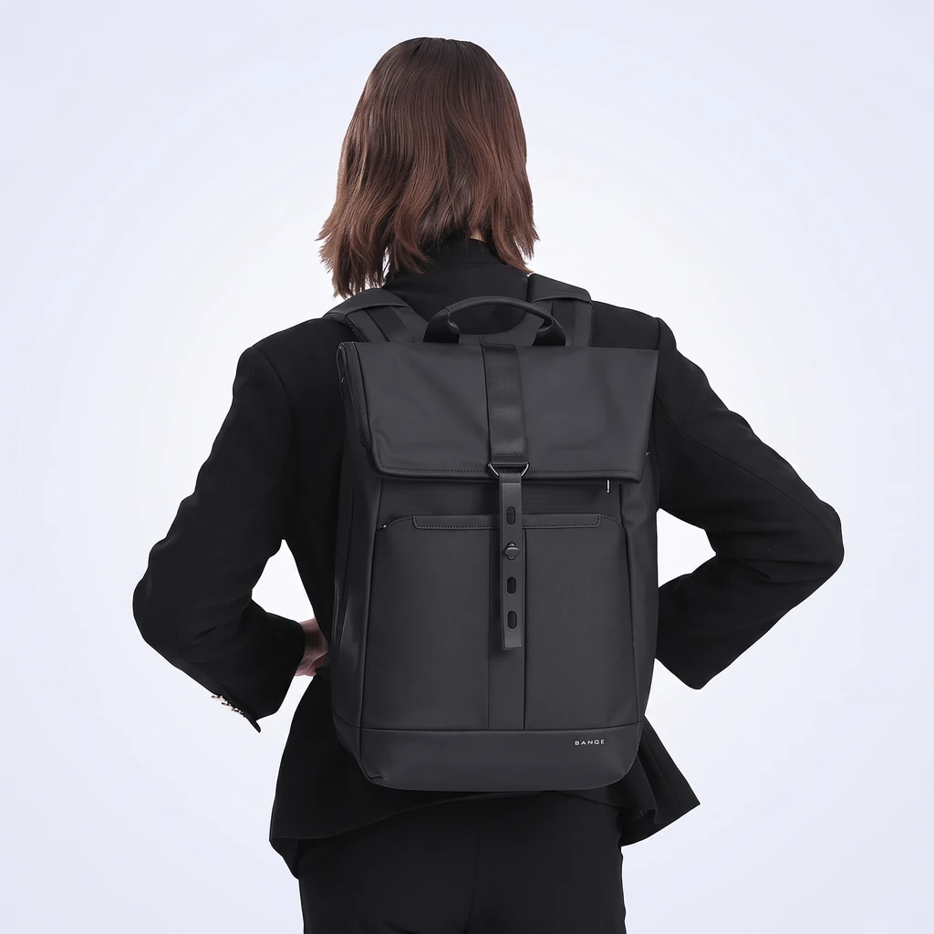 黒いブレザーを着用したビジネスマンが、スタイリッシュな防水20Lメンズビジネスリュックを背負っている後ろ姿のスタジオ写真。