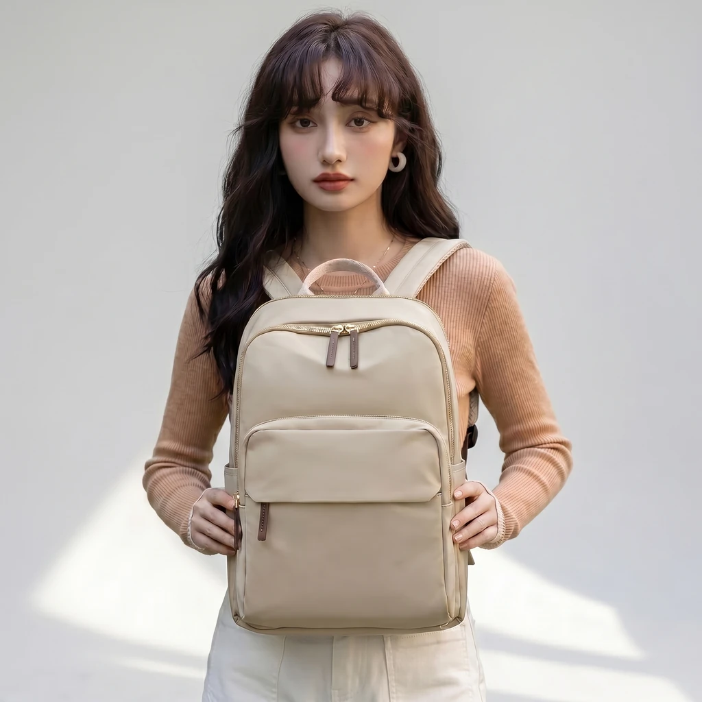 ベージュのニットを着たエレガントな女性が持つ、パソコン収納対応の15.6インチ20Lスリムビジネスリュックサック