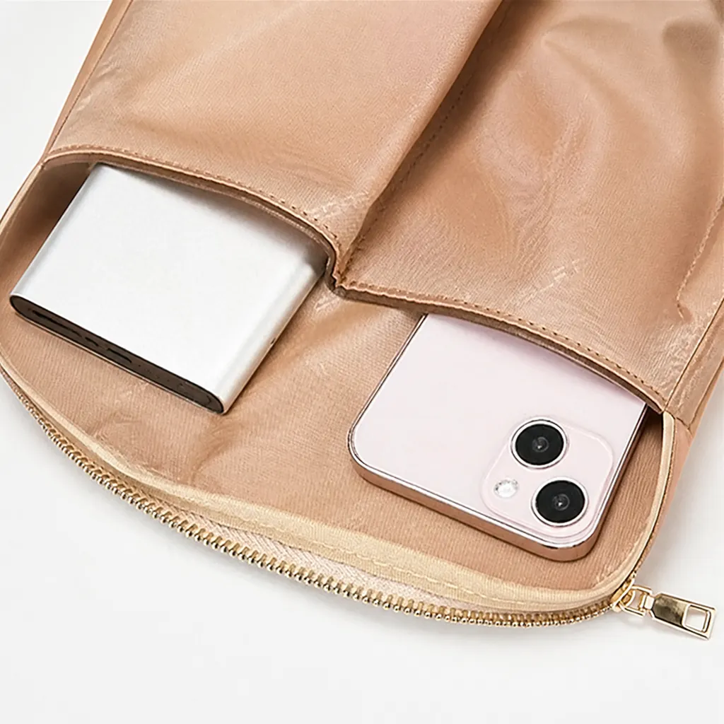 女性向け通勤リュックの内側。ベージュの総柄裏地と、スマホやモバイルバッテリーがきれいに収納された便利な内ポケットのクローズアップ。