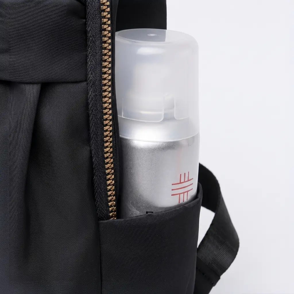 軽量レディースビジネスリュック 12L A4サイズ ゴールドのファスナーがおしゃれな黒の軽量レディースビジネスリュック。サイドポケットにシルバーのボトルが収納されています。