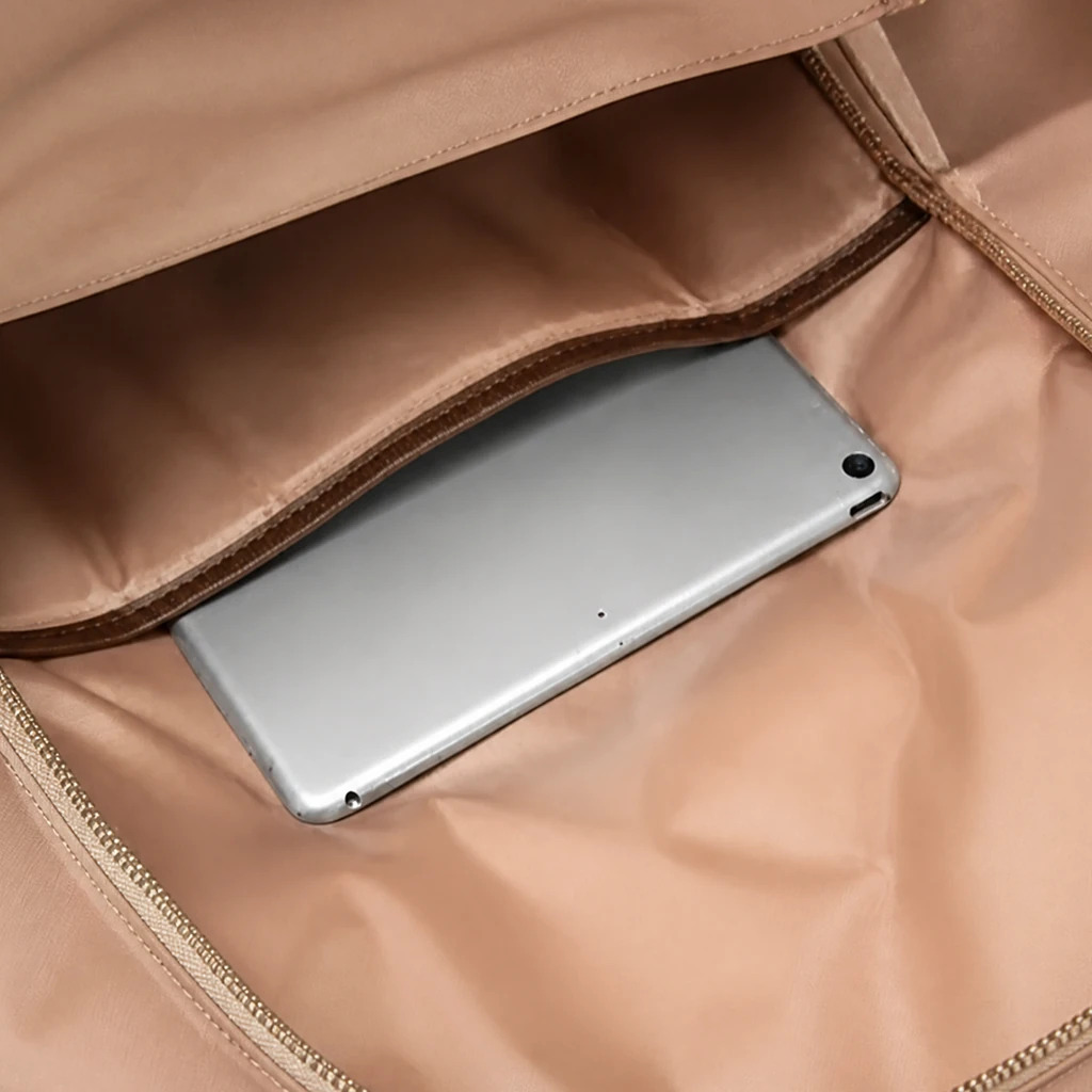 レディースリュックの上品な内部収納とタブレットポケット ベージュの上品な裏地が施されたレディースリュックの内部。専用ポケットにスマートに収納されたタブレットのクローズアップ。