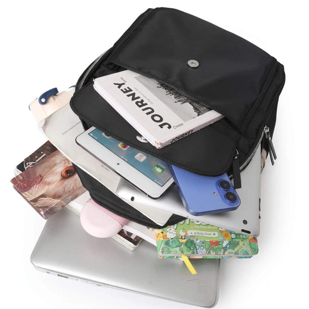 白背景に平置きされた、ノートPCやスマホ、ノートなどの仕事道具が美しく収納できる、女性向けの防水仕様20Lおしゃれバックパック。